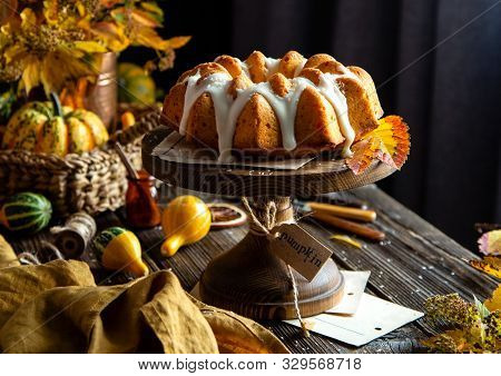 Homemade Tasty Baked Bundt Pumpkin Cake With Glaze On Top On Wooden Cake Stand On Rustic Table With 