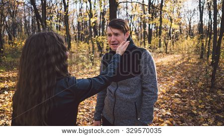A Womans Hand Hits A Mans Face In The Autumn Forest. An Emotional Male Is Getting Slapped In Face, W