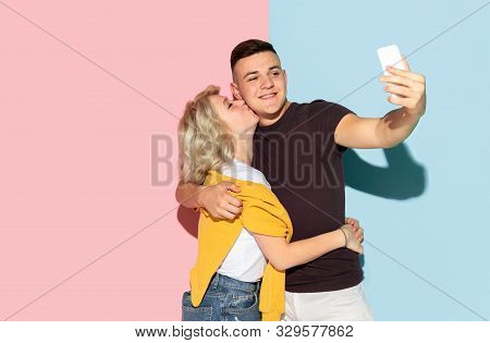 Young Emotional Man And Woman In Bright Casual Clothes Posing On Pink And Blue Background. Concept O