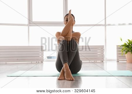 Young Woman Practicing Eagle Asana In Yoga Studio. Garudasana Pose