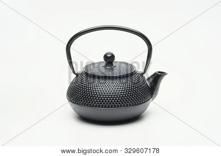 Black Cast Iron Teapot On A White Background.