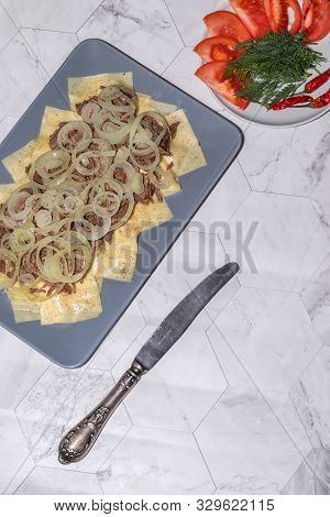 Beshbarmak Is A National Kyrgyz Dish - Square Pasta With Boiled Meat And Onions. On A Light Backgrou