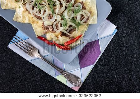 Beshbarmak Is A National Tatar Dish - Square Pasta With Boiled Meat And Onions. On A Black Backgroun