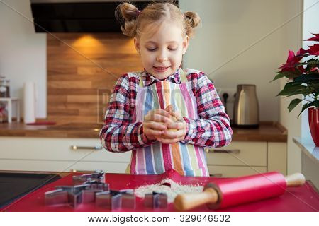 Pretty Little Girl With Funny Pigtails Decoraiting Christmas Cookies Of Different Forms In Kitchen