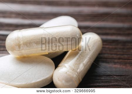 White Medical Capsules Of Glucosamine Chondroitin, Healthy Supplement Pills On Wooden Background, Ma