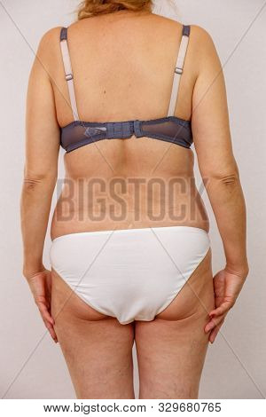 An Elderly Naked Woman Shows Her Body From All Sides. You Can See All The Nuances Of The Elderly Bod