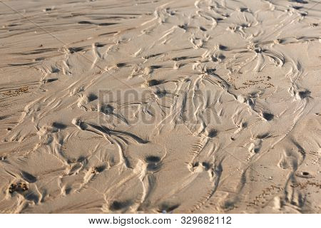 Background Pattern Of Seawaves On The Beach During Low Tide