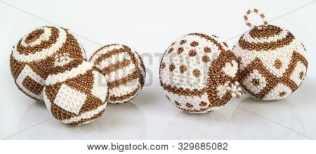 A Picture Of Five Varied White And Gold Beaded Balls Christmas Tree Decorations