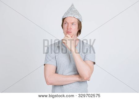 Young Man With Tinfoil Hat As Conspiracy Theory Concept Thinking