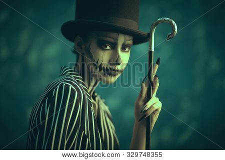 Elegant young woman in a male tailcoat and top-hat with pumpkin skull make-up. Pumpkin queen. Costumes and makeup for Halloween.
