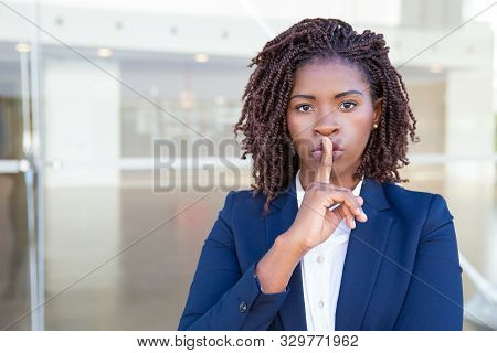 Serious Silent Professional Keeping Secret. Young Black Business Woman Standing At Outdoor Glass Wal