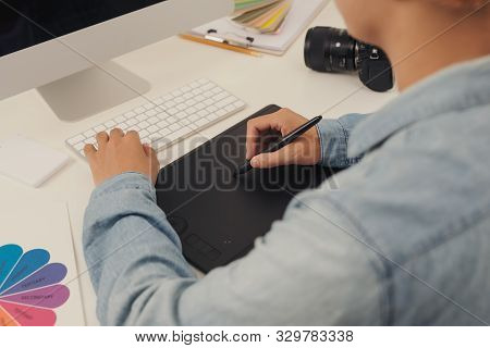 Photographer Drawing And Retouching Image On Laptop Computer, Using A Digital Tablet And Stylus Pen.