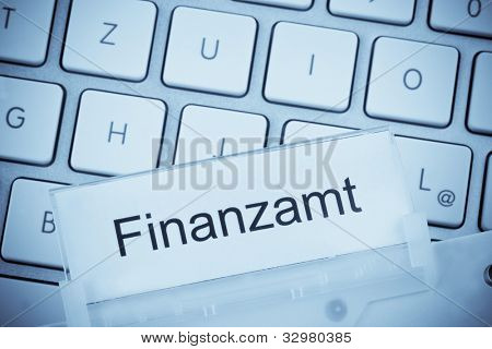Složka pro soubory v závěsném složky před klávesnicí počítače na téma: finanční úřad