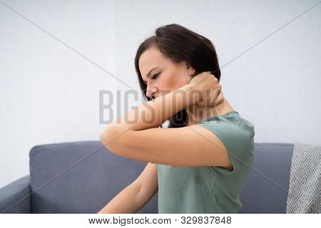 Woman Having Neck Pain Sitting At Home