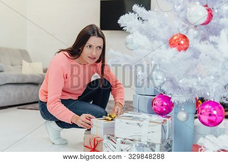 Childish Mother Comes Unnoticed To Christmas Tree At Night, Behaving As If She Wants To Steal A Pres