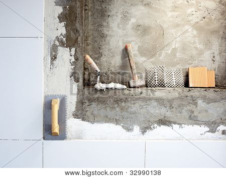 truelle à dents de construction outils et marteau sur carreaux de mur de mortier
