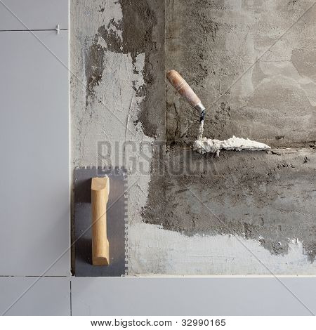truelle d'outils construction sur carreaux de mur de mortier