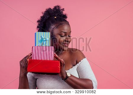 Happy Afro Woman Holding Gift Boxes March 8 In Stusio Pink Background