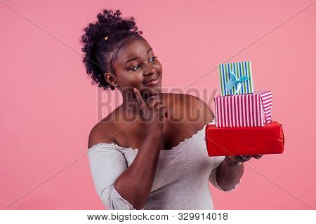Happy Afro Woman Holding Gift Boxes March 8 In Stusio Pink Background