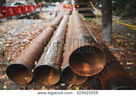 Shallow Depth Of Field (selective Focus) Image With Rusty Iron Water Pipes On The Sidewalk With Fall