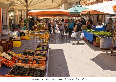 Lamia Greece - July 26 2019; People With Their Purchases Walk Between City Street Market  Produce Ve