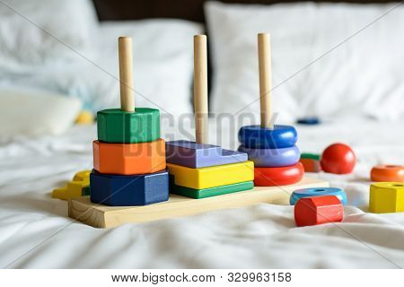 Wooden Colorful Blocks And Sorting Shapes On The Bed