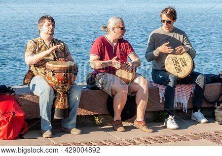 Petrozavodsk, Russia - 13 June 2020. Three Street Musicians Playing Drums Jembe For Donation
