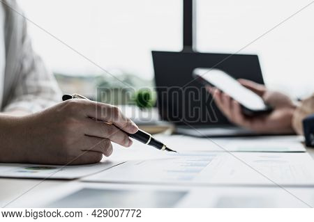 Two Businessmen Are Brainstorming Together And Reviewing The Company Financial Documents That The Fi