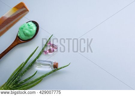 Hair Spa Care Set With Treatment, Leaves Aloe Vera, Coconut Oil, Vitamin E, Comb On Blue Background.