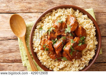 Stew Pork Marinated In Red Wine Afelia With Bulgur Closeup In The Bowl On The Table. Horizontal Top 
