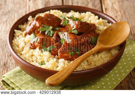 Slowly Braised Pork In Red Wine Served With Bulgur Close-up In A Bowl On The Table. Horizontal