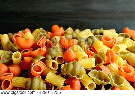 Pile Of Three-color Dried Vegeroni Pasta On Black Background With Copy Space