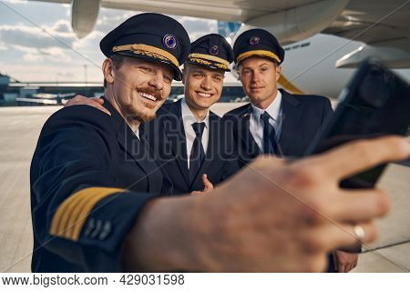 Three Airmen In Uniforms Taking Selfies At The Airport