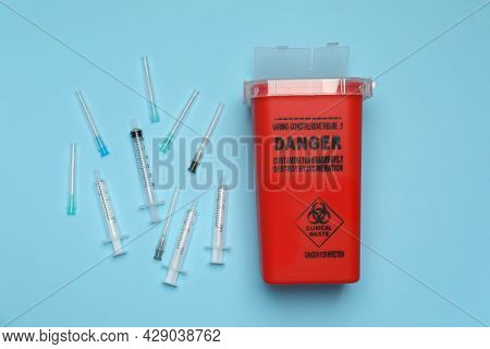 Disposable Syringes, Needles And Sharps Container On Light Blue Background, Flat Lay
