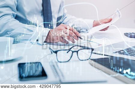 Businessman Trader Is Sitting At Workplace And Working With Documents To Continue Trading Operations
