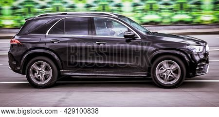 Young Woman Driving Mercedes-benz Gle-class In The City Street On High Speed. Fast Moving Black Suv 