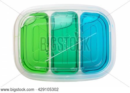Colored Slimes In A Transparent Plastic Container On A White Background Close-up