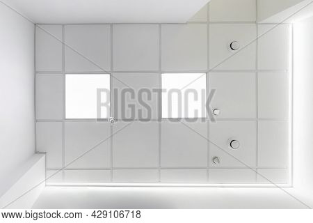 Cassette Suspended Ceiling With Square Halogen Spots Lamps And Drywall Construction In Empty Room In