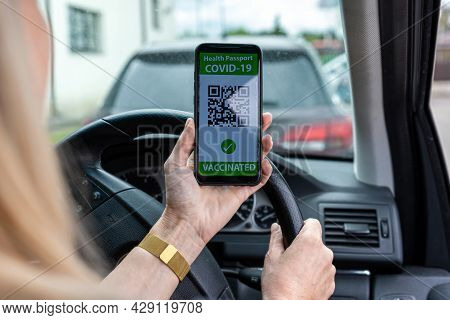 Driver In Car Shows A Digital Covid-19 Immunity Vaccine Passport, New Normal Travel Concept