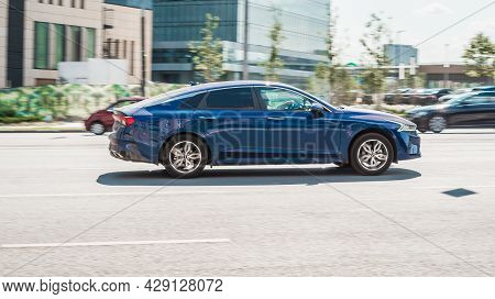 Kia K5 Optima Dl3 On The City Road. Fast Moving Blue Shiny Korean Car On The Street. Vehicle Driving