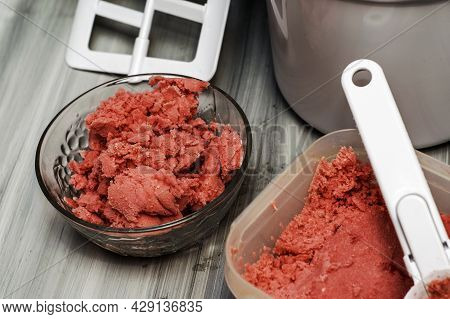 Homemade Cherry Ice Cream In A Glass Socket And A Plastic Container On The Table Next To An Ice Crea