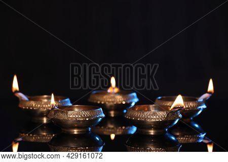 Many Lit Diyas On Black Background, Space For Text. Diwali Lamps
