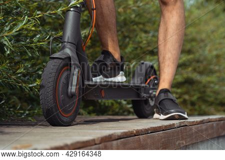Close Up Of Man Riding Electric Kick Scooter At Beautiful Park Landscape
