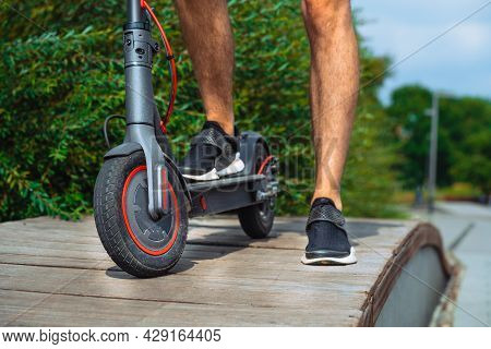 Close Up Of Man Riding Electric Kick Scooter At Beautiful Park Landscape