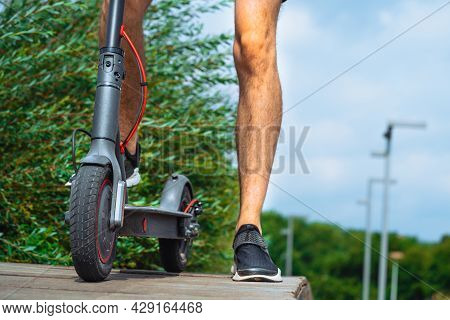 Close Up Of Man Riding Electric Scooter At Beautiful Park Landscape