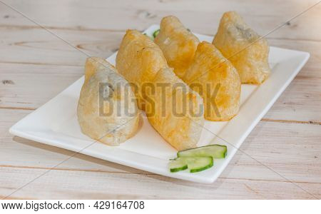 Japanese Inari-zushi With Rice And Tofu Served On A White Plate