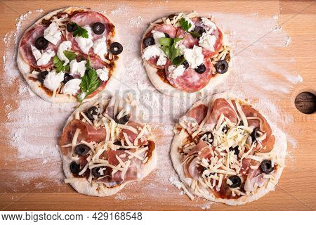 Four Mini Pizzas On A Wooden Board With Flour Before Baking, Italian Appetizer - Top View
