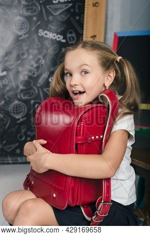 Happy Schoolchild In The Classroom With Big Backpack And Positive Emotions. Excieted And Ready To St