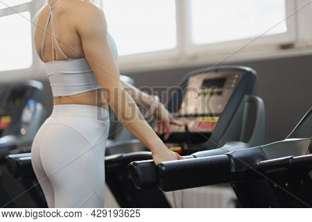 Athletic Girl Turns On Treadmill For Training Closeup