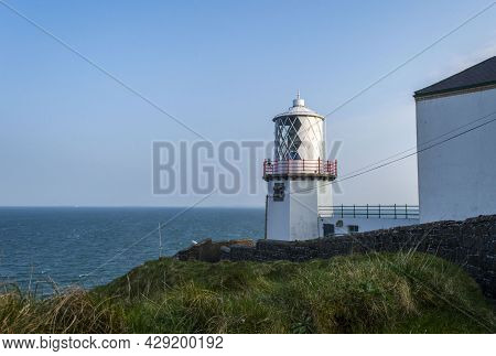 Whitehead, Carrickfergus, Uk, April, 2019. The Blackhead Lighthouse At Whitehead In A Sunny Day.